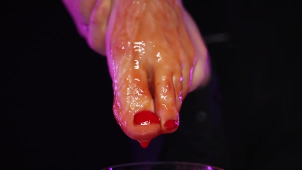Tomato juice flows down womans beautiful red pedicure leg into glass of ice — Stock Video