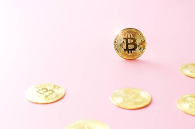 Açık pembe arka planda altın Bitcoin 'i kapat. Kripto para birimi sembolü. Parlak bitcoin altın madeni paralar arasında yer alır..