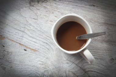 Kahve fincanı ve kaşık tahta arka planda..