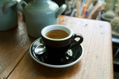 Siyah kahve fincanı ahşap masada.