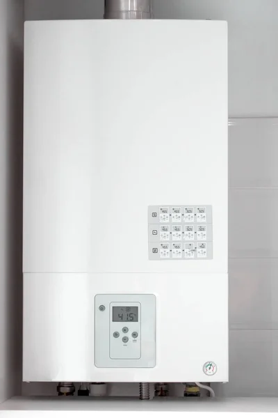 White electric water heater with electronic panel mounted in a kitchen cabinet