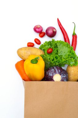 Beyaz arka planda kağıt torbalarda taze sebzeler.