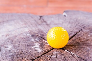 Beyaz zemin üzerine sarı minyatür Golf topu.