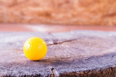 Beyaz zemin üzerine sarı minyatür Golf topu.