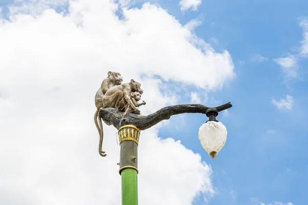 Άγαλμα του μια οικογένεια μαϊμού λάμπα μετά στο γαλάζιο του ουρανού. — Φωτογραφία Αρχείου