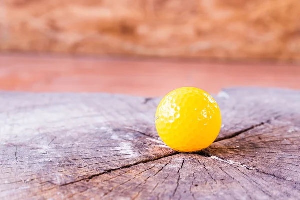 Beyaz zemin üzerine sarı minyatür Golf topu.