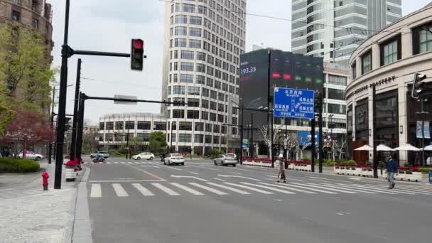 SHANGHAI, CINA - 31 MARZO 2022: la gente attraversa una strada vuota nel centro della città — Video Stock