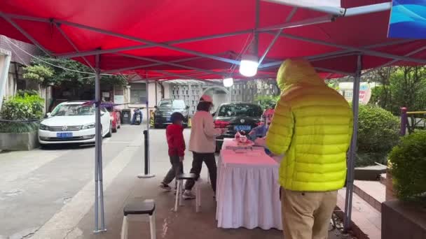 ШАНХАЙ, Китай - 3 апреля 2022 года: Люди проходят обязательные ковидовые тесты — стоковое видео