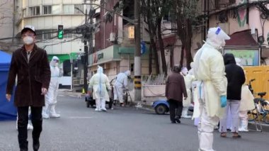 SHANGHAI, ÇİN - 4 Nisan 2022: Tehlikeli madde giysileri içinde hükümet çalışanları caddeyi kapattı