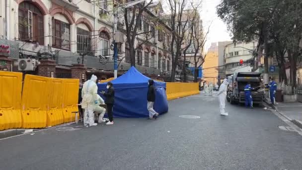 SHANGHAI, CHINA - APRIL 4, 2022: заблоковано вулицю з людьми в костюмах для небезпек. — стокове відео