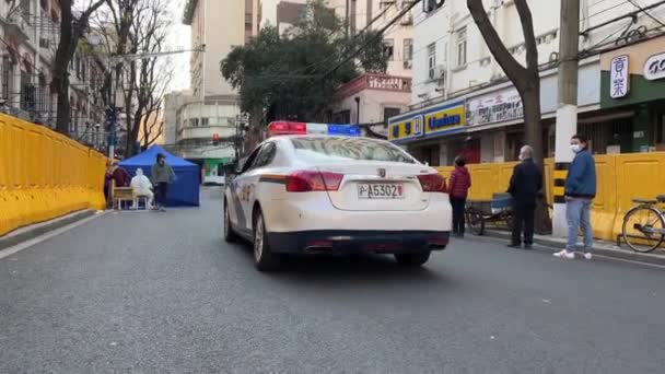 SHANGHAI, CHINE - 4 AVRIL 2022 : Une voiture de police passe la ligne d'essai covid — Video