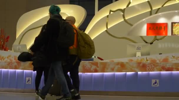 HONGKONG - 23. JANUAR 2020: Junge Frau mit Gepäck fragt beim Kundenservice am Flughafen nach Informationen — Stockvideo