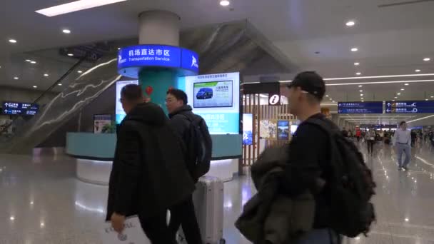 HONG KONG - JANUARI 23, 2020: Drie mannen van middelbare leeftijd die met hun bagage op de luchthaven van Hongkong lopen Videoclip