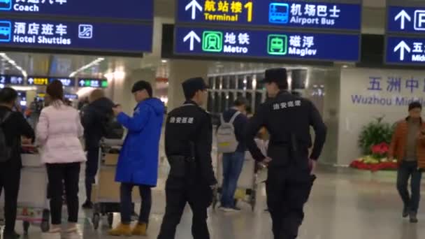 HONG KONG - JANUARY 23, 2020: Airport security in a uniform walk by the airport signs — Stock Video
