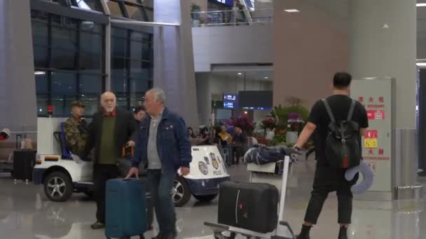 HONG KONG - STYCZEŃ 23, 2020: Żołnierze w samochodzie na lotnisku i człowiek stoi z bagażem w Chinach — Wideo stockowe