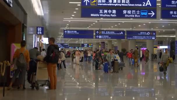 HONG KONG - 23 JANUARI 2020: Blå flygplatstecken och personer som passerar vid en upptagen flygplats i Hongkong — Stockvideo