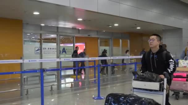 HONG KONG - 23 DE ENERO DE 2020: Los pasajeros llevan su equipaje en un aeropuerto — Vídeo de stock