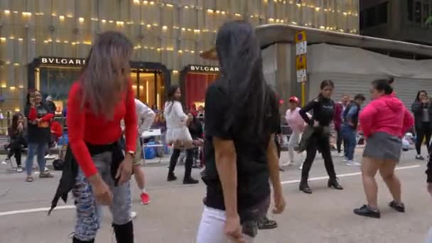 HONG KONG - JANUARI 23, 2020: Twee gelukkige Chinese vrouwen dansen met een menigte op straat in een grote stad — Stockvideo