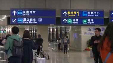 HONG KONG - 23 HAZİRAN 2020: Mavi havaalanı tabelası ve Hong Kong havaalanından geçen insanlar