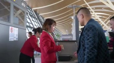 HONG KONG - 20 HAZİRAN 2020: Kadın işçiler Hong Kong havaalanındaki uçağa binmeden önce kapıdaki yolcuları kontrol ediyorlar.