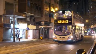 HONG KONG - 22 HAZİRAN 2020: yoğun bir Hong Kong caddesinde gece otobüsler ve arabalar. Çin 'de şehir hayatı