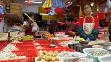 HONG KONG - 21 Ocak 2020: Yaşlı kadınlar Hong Kong, Çin 'deki kalabalık yerel gıda pazarında yiyecek satıyorlar