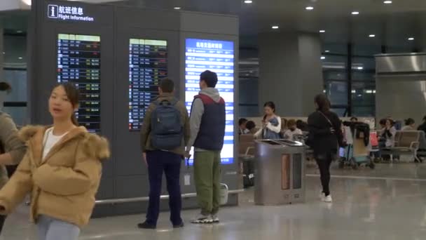 HONG KONG - 23. června 2020: Číňané se dívají na letový řád na letišti a lidé míjejí — Stock video