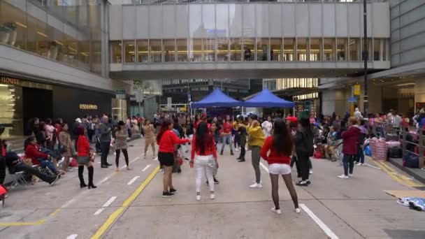 HONG KONG - JANEIRO 23, 2020: Uma multidão de pessoas felizes dançando juntas em uma rua movimentada, zoom out — Vídeo de Stock