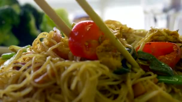 Het nemen van heerlijke voedzame schotel met noedels en groenten met stokjes Chinees voedsel Rechtenvrije Stockvideo's