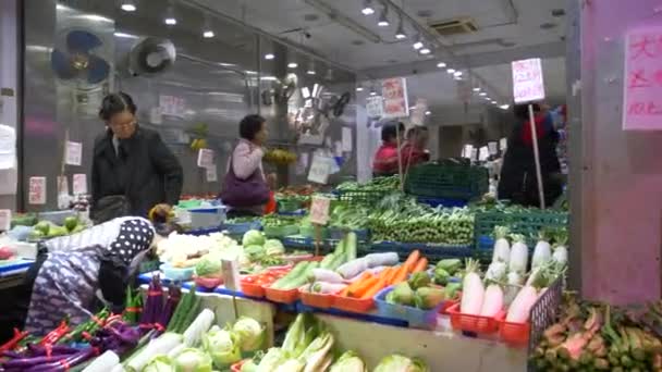 La gente compra verduras frescas en el concurrido mercado local de alimentos en Hong Kong, China — Vídeos de Stock