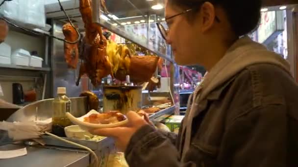 HONG KONG - JANUARY 21, 2020: Pretty woman takes food at meat counter at the food market in Hong Kong, China — стоковое видео