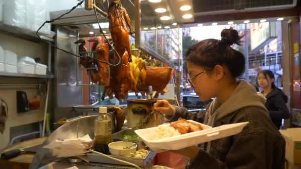 HONG KONG - JANUARY 21, 2020: Woman takes food at meat counter at the food market in Hong Kong, China — стоковое видео