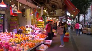 HONG KONG - 21 HAZİRAN 2020: Kalabalık tezgahların önünden geçiyor ve Çin 'deki gıda pazarından sebze ve meyve alıyor
