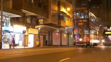 HONG KONG - 22 HAZİRAN 2020: yoğun bir Hong Kong caddesinde gece vakti siyah çift güverteli araçlar. Çin 'de şehir hayatı