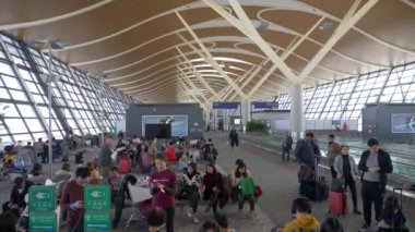 HONG KONG - 20 ARALIK 2019: İnsanlar havaalanındaki yolcu salonunda bavullarıyla bekliyor