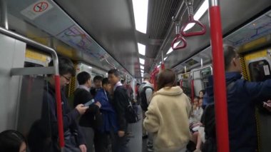 HONG KONG - 21 Ocak 2020: Hong Kong metro istasyonunda kalabalık bir trende oturan ve ayakta duran yolcular
