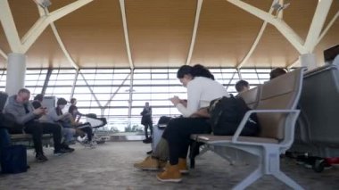 HONG KONG - 20 ARALIK 2019: İnsanlar havaalanındaki yolcu salonunda bavullarıyla bekliyor