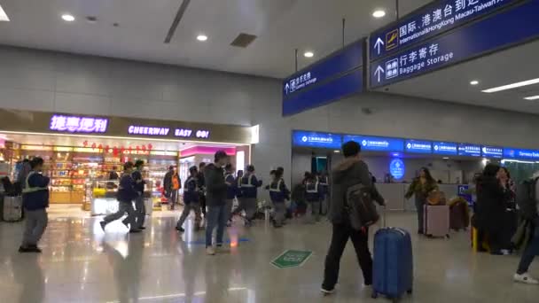 HONG KONG - STYCZEŃ 30, 2020: Pracownicy lotniska biegną w pośpiechu na lotnisku, a ludzie przechodzą obok w Hongkongu — Wideo stockowe