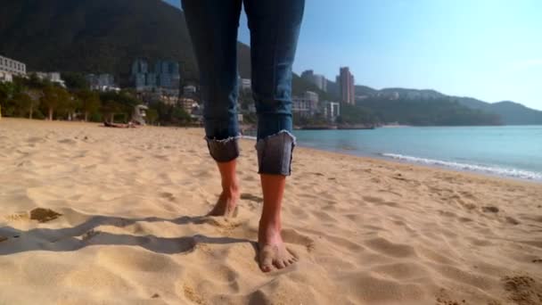 Poten van een mooie jonge vrouw die overdag in slow motion langs het Hong Kong strand loopt Rechtenvrije Stockvideo
