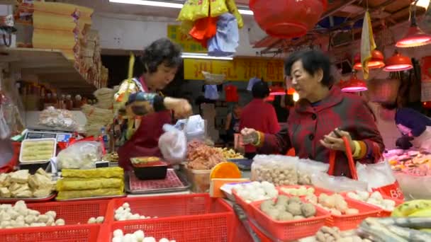 HONG KONG - 21 DE ENERO DE 2020: Una anciana compra comida en el abarrotado mercado local de alimentos en Hong Kong, China — Vídeos de Stock