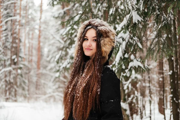 Fiatal Fekete Kabátban Áll Lucfenyő Alatt Téli Erdőben Szabadban Mosolygós — Stock Fotó