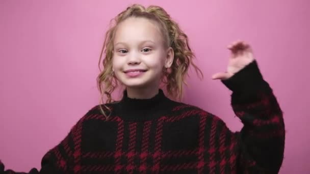 Smiling little girl makes heart with hands on pink background. Valentines day love symbol gesture with hands. Lifestyle and emotions — Vídeo de Stock