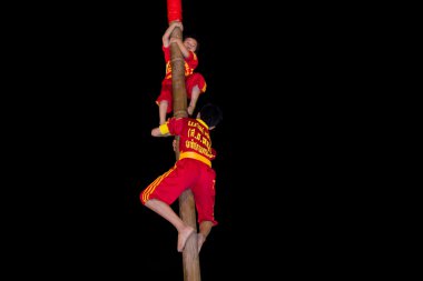 akrobatlar ahşap direğe tırmanma vardır