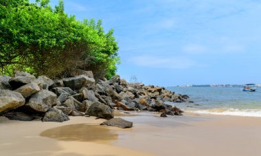 Galle, Sri Lanka 'daki inanılmaz kayalık beyaz kumlu plaj. Güneşli bir günde Orman Sahili 'nin resmi. Yeşillik, plaj kayaları ve sakin deniz dalgaları. Galle 'de Manzaralı Turizm.