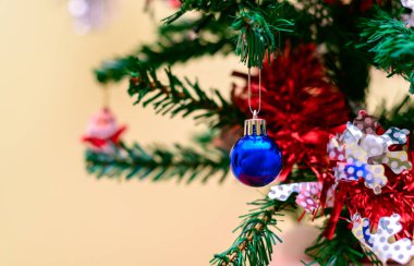 Süslü bir Noel ağacında parlak mavi bir mücevher kapanıyor..