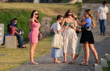 Galle, Sri Lanka - 02 03 2022: Kadın arkadaşlar, Sri Lanka 'daki güzel bir turizm merkezi olan Galle Fort' ta akşamın tadını çıkarıyorlar. Genç ve güzel bir kız arkadaşının fotoğrafını cep telefonuyla çekiyor..