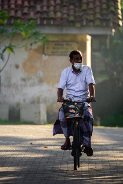 Galle, Sri Lanka - 02 26 2022: Sri Lanka 'da günlük yaşam kavramı, yaşlılar sabahın erken saatlerinde bisiklet sürüyor,