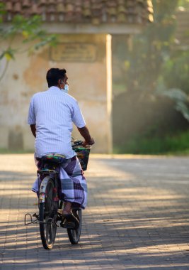 Galle, Sri Lanka - 02 26 2022: Sri Lanka 'da günlük yaşam kavramı, yaşlılar sabahın erken saatlerinde bisiklete binip gidiyorlar,