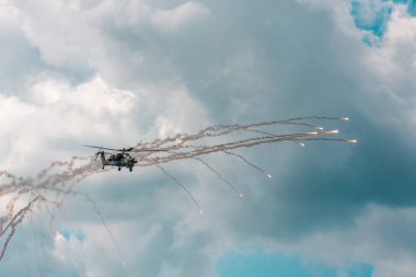 Rus askeri saldırı helikopteri Moskova 'daki MACS hava gösterisinde Rus hava kuvvetleri gösterisinde işaret fişeği atıyor.