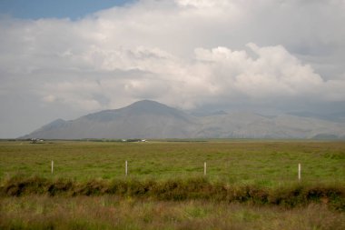 Çevre yolu boyunca dağlık zemini olan otlak bir arazi.